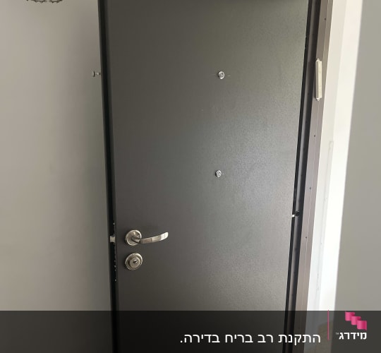 דלת מתכת אפורה עם ידית כסופה פתוחה חלקית